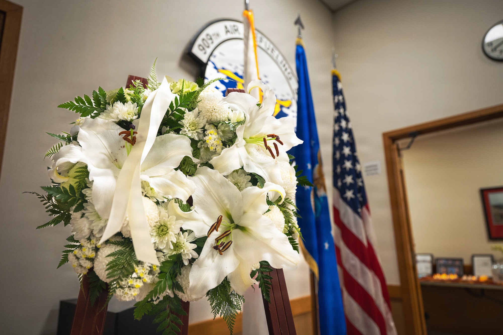 A bouquet of flowers is placed at the entrance of the 909th Air Refueling Squadron during a vigil at Kadena Air Base, Japan, March 20, 2026.