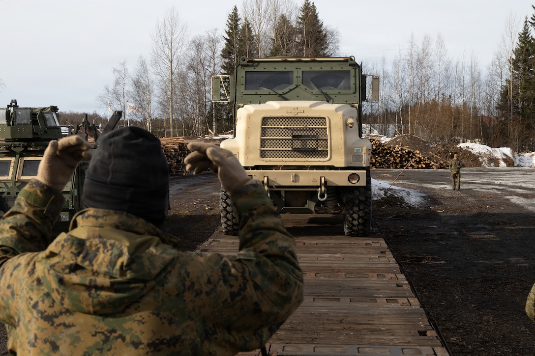 U.S. Marine Corps Lance Cpl. Edgar RamosUrbano, a motor vehicle operator with Combat Logistics Battalion 6, Combat Logistics Regiment 2, 2nd Marine Logistics Group, guides a medium tactical vehicle replacement in Haparanda, Sweden, March 22, 2026. RamosUrbano guided the medium tactical vehicle replacement onto a train using a railhead after the conclusion of exercise Cold Response 26. A key component of NATO's enhanced vigilance activity Arctic Sentry, exercise Cold Response 26 is a Norwegian-led winter military exercise designed to enhance collective defense capabilities and ensure U.S. readiness to rapidly deploy and seamlessly operate alongside NATO Allies in challenging arctic conditions. RamosUrbano is a native of New York. (U.S. Marine Corps photo by Cpl. Apollo Wilson)