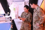 U.S. Air Force Capt. Pei-Ying Kobres, University of California, Davis, emergency resident physician, left, and U.S. Army Capt. Colin Rose, Brooke Army Medical Center resident physician, review the contents of a crash cart during the National Disaster Medical System Modular/Convertible Capability Pilot, Sept. 11, 2025, on the BAMC campus. The NDMS modular capability pilot is developing a new capability for modular surge solutions to expand NDMS partner hospital bed capacity to respond to medical surges during large-scale combat operations, a natural disaster or pandemic. (DoW photo by Robert A. Whetstone)