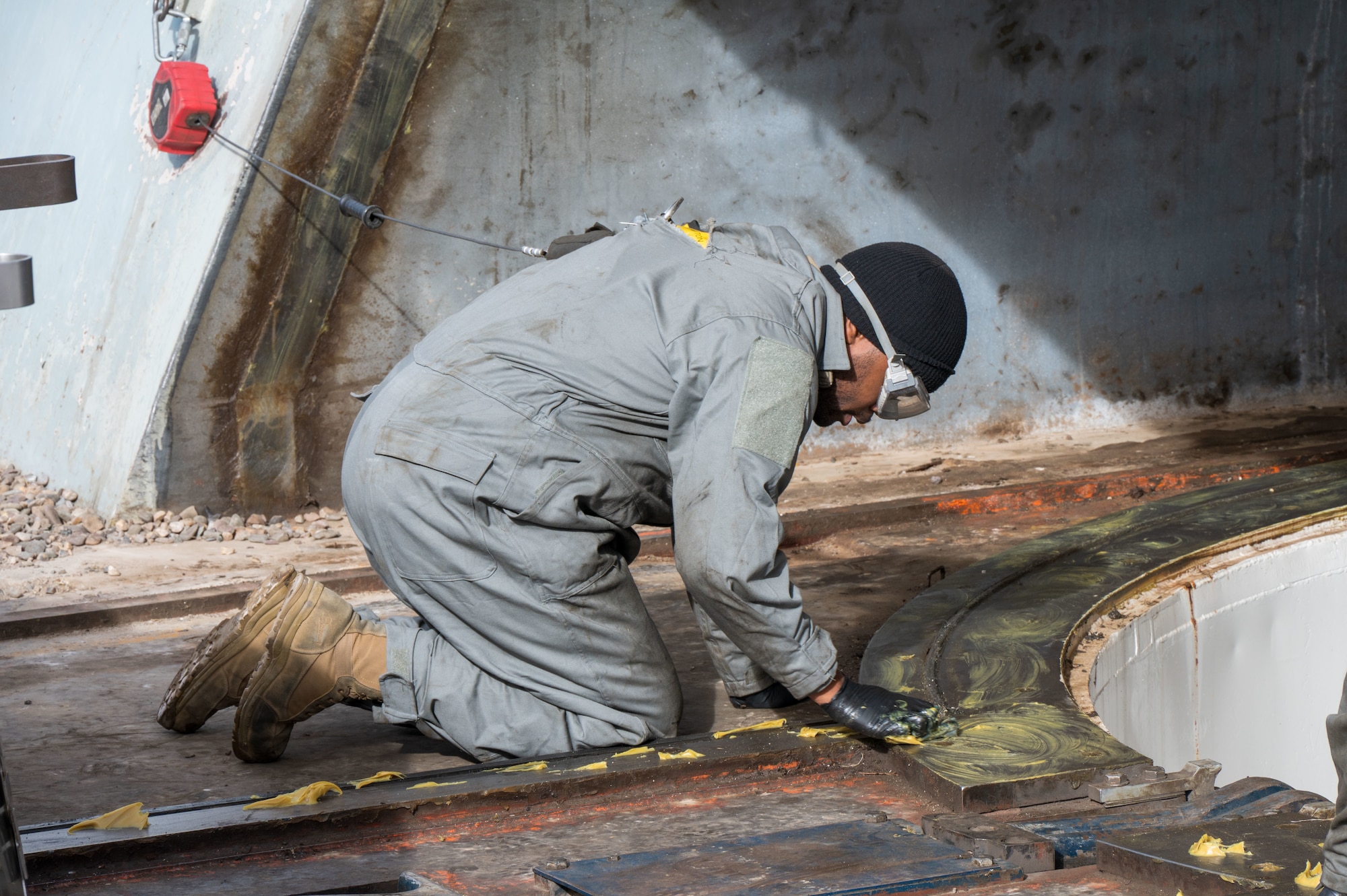 A uniformed man applies paste to a trainer missile silo.