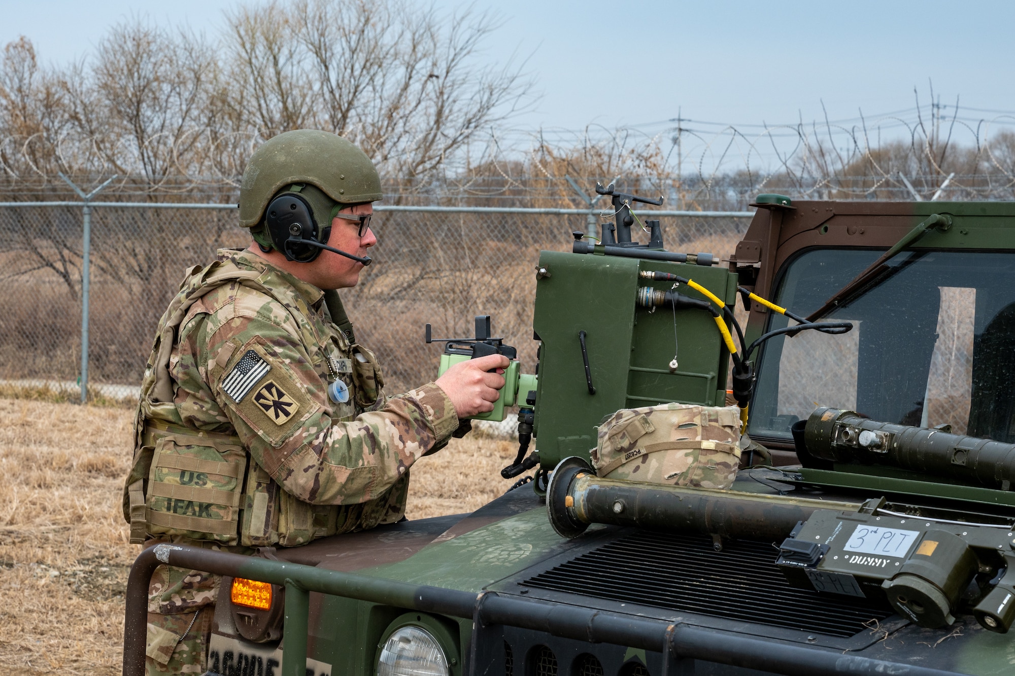 A Soldier uses a remote control unit to scan target a small, unmanned aerial system.