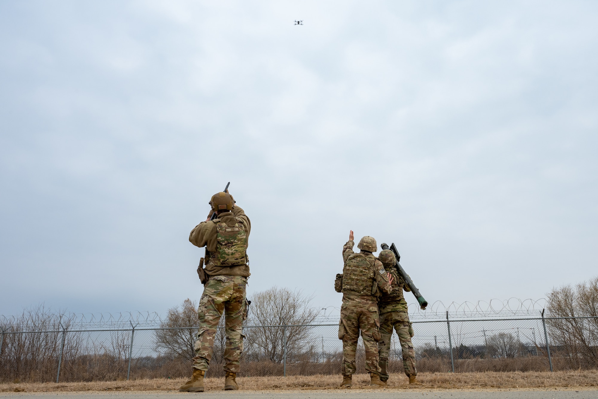 An Airman and Soldiers target a small, unmanned aerial system.