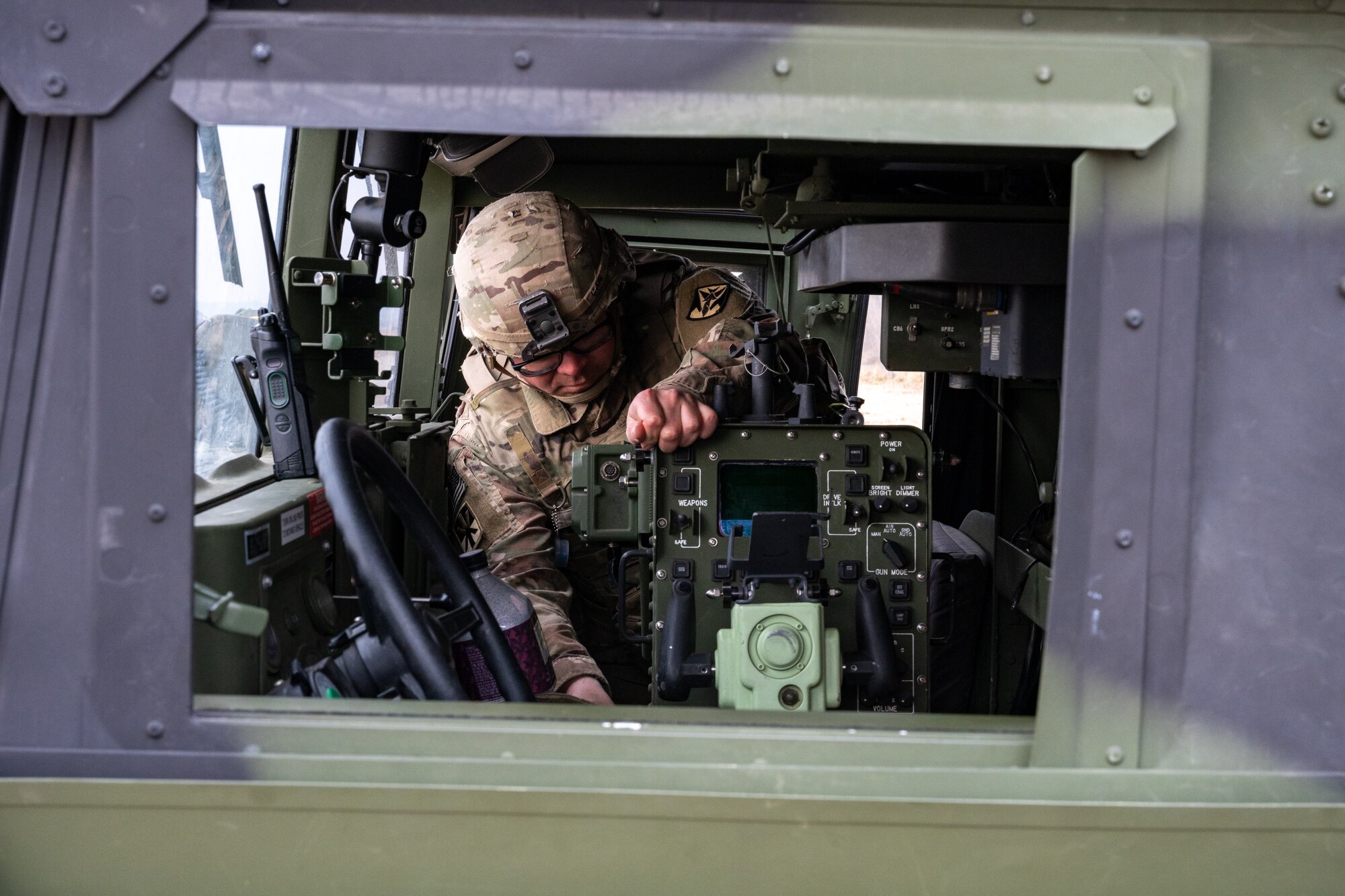 A Soldier inserts a control unit back into a vehicle.