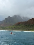 A Coast Guard Air Station Barbers Point MH-65 Dolphin helicopter crew and a Kauai Ocean Safety Bureau boat crew traverse the shoreline near Kalalau Beach on Kauai March 26, 2026. The Coast Guard received a report from Kauai Police Dispatch of a helicopter crash-landing near Kalalau Beach with five people aboard. (U.S. Coast Guard photo, courtesy Station Kauai)