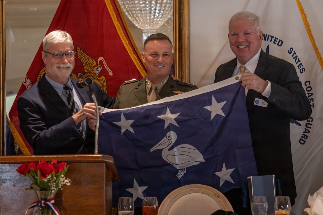 U.S. Marine Corps Lt. Gen. Leonard F. Anderson IV, center, commander of Marine Forces Reserve and Marine Forces South, receives a gift from Jim Letten, left, former president, and John Kelly, right, president, of the New Orleans Navy League at the Metairie Country Club, Metairie, Louisiana, March 18, 2026. The New Orleans Navy League hosted the event to recognize and award service members in the New Orleans area. (U.S. Marine Corps photo by Lance Cpl. Edward Spears)