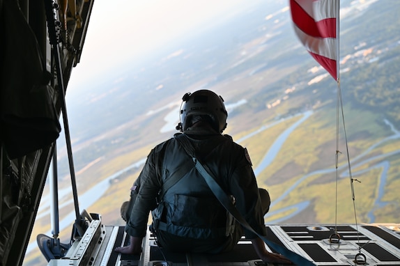 U.S. Staff Sgt. Jon Ferraris, a loadmaster, assigned to the 158th Airlift Squadron, 165th Airlift Wing (AW), Georgia Air National Guard, sits on the ramp of a C-130J Super Hercules over Savannah, Georgia, Sept. 6, 2025. The 165 AW conducted a flyover during the annual Patriot Day 5K Run in Savannah, Georgia, to honor the nearly 3,000 lives lost on Sept. 11, 2001.(U.S. Air National Guard photo by Staff Sgt. Victoria Coursey)