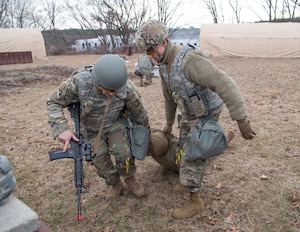 Image of two Airmen dragging someone to safety during a training exercise.