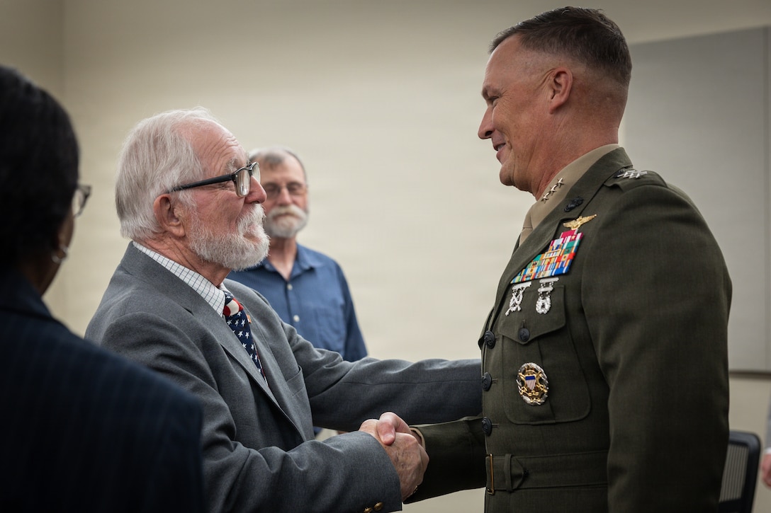 Allan McPherson, left, brother of the late Maj. Everette McPherson, shakes the hand of Lt. Gen. Leonard F. Anderson IV, right, commander of Marine Forces Reserve and Marine Forces South, before a posthumous Distinguished Flying Cross ceremony honoring the heroic actions of his brother at Marine Support Facility New Orleans, March 18, 2026. The Distinguished Flying Cross is awarded to those who have displayed single acts of heroism or extraordinary achievement while participating in aerial flight. Maj. McPherson, a fighter jet pilot, posthumously received the award for sacrificing his life during the Vietnam War in an attempt to save the life of his co-pilot. (U.S. Marine Corps photo by Lance Cpl. Claire Cheney)