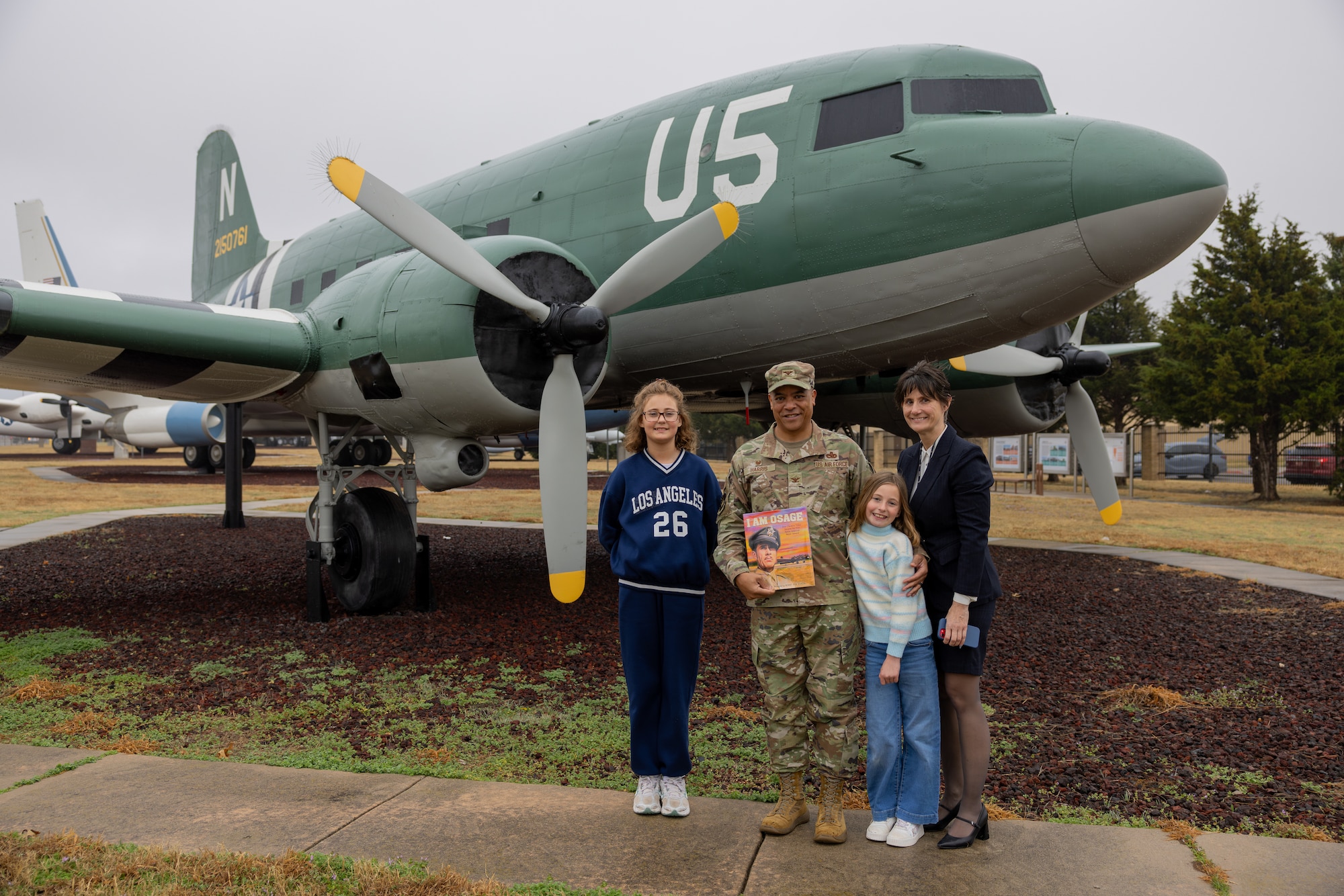 Man, woman and two girls standing in front of C-47 aircraft display