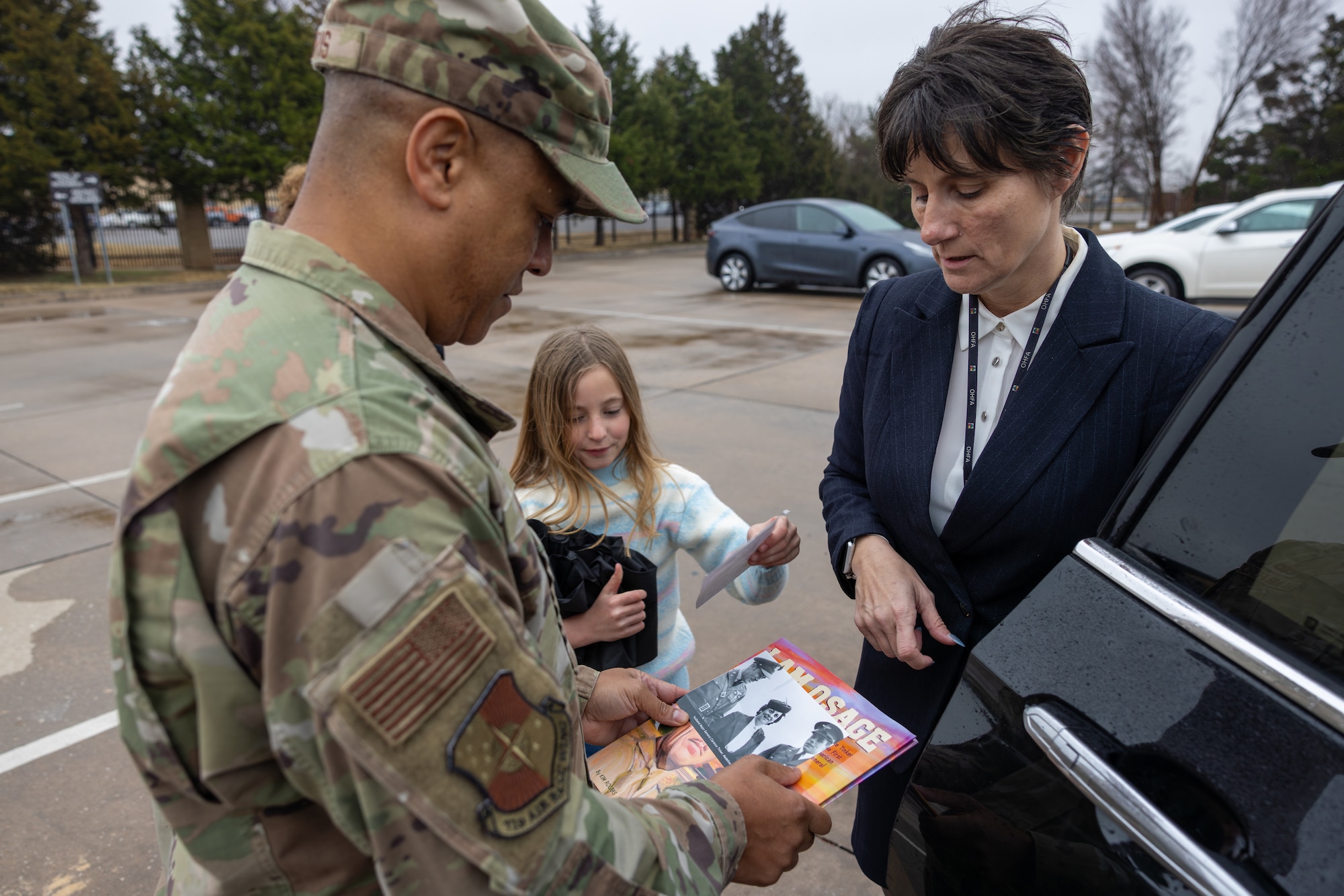 Man, woman and girl looking at photo