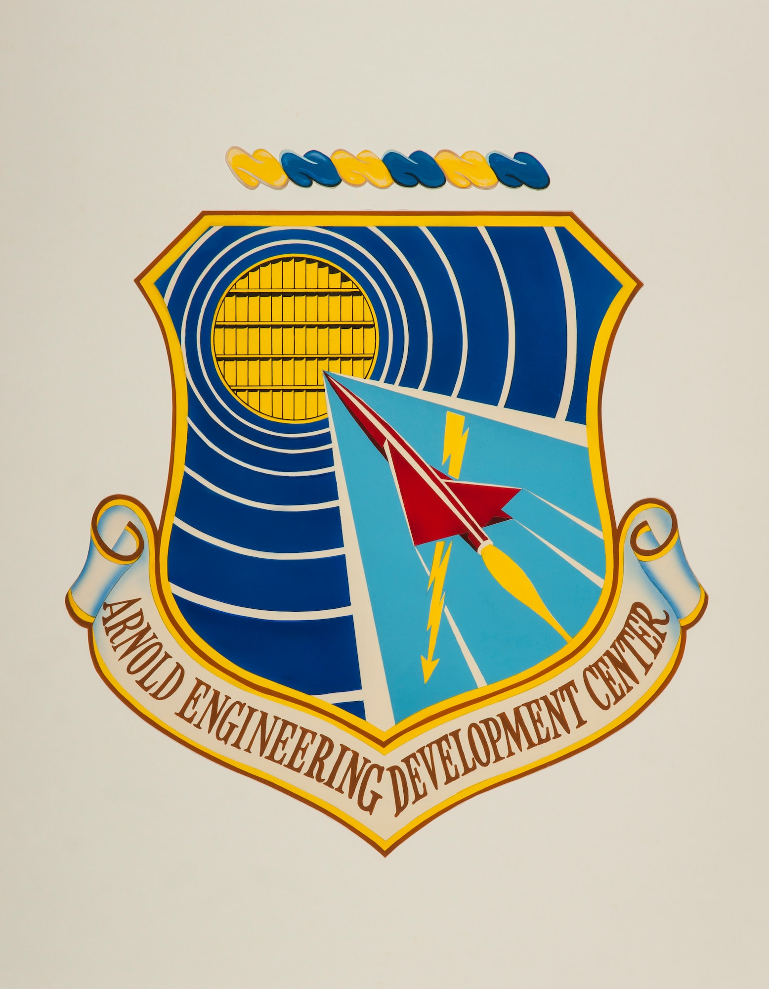 Pictured is the original Arnold Engineering Development Center emblem first approved in 1957. A revised version of the emblem, in line with the one still used by AEDC, was officially approved in August 1994. (U.S. Air Force graphic)