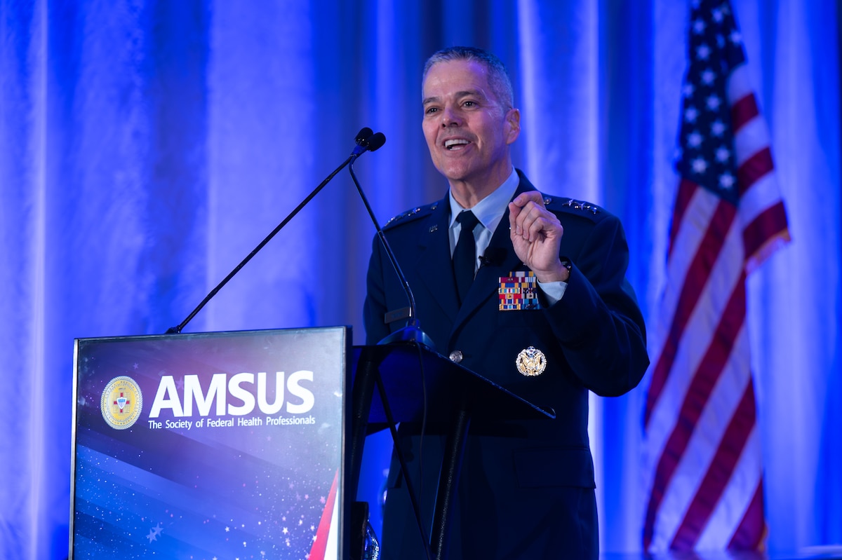 Image of an Airman talking at a podium.