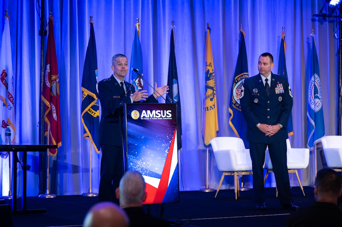 Image of an Airman talking at a podium.