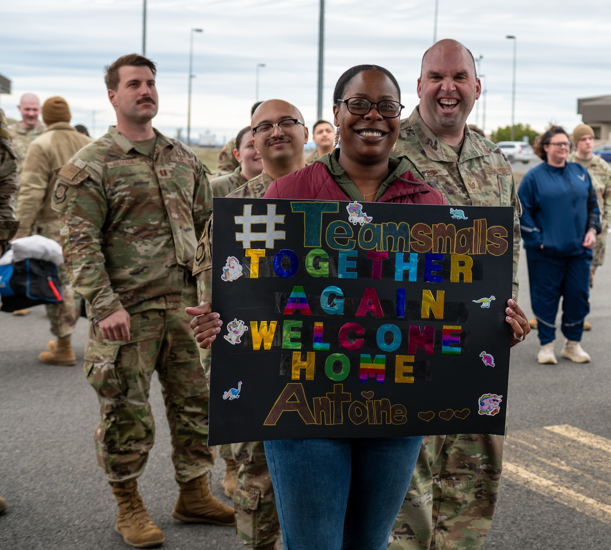 The spouse of a deployed Airman holds a sign.