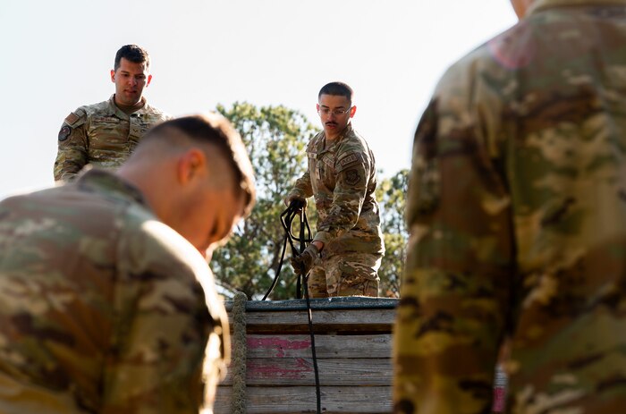U.S. Air Force Senior Airman Adrian Pena, 437th Maintenance Group aerospace ground equipment specialist, places a rope down to hoist up another Airman during an Airman Leadership School field training exercise at the Marine Corps Recruiting Depot, Parris Island, South Carolina.