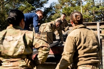 U.S. Airmen work together with a Coastguardsman to move ammo cans during an Airman Leadership School field training exercise at the Marine Corps Recruiting Depot, Parris Island, South Carolina.