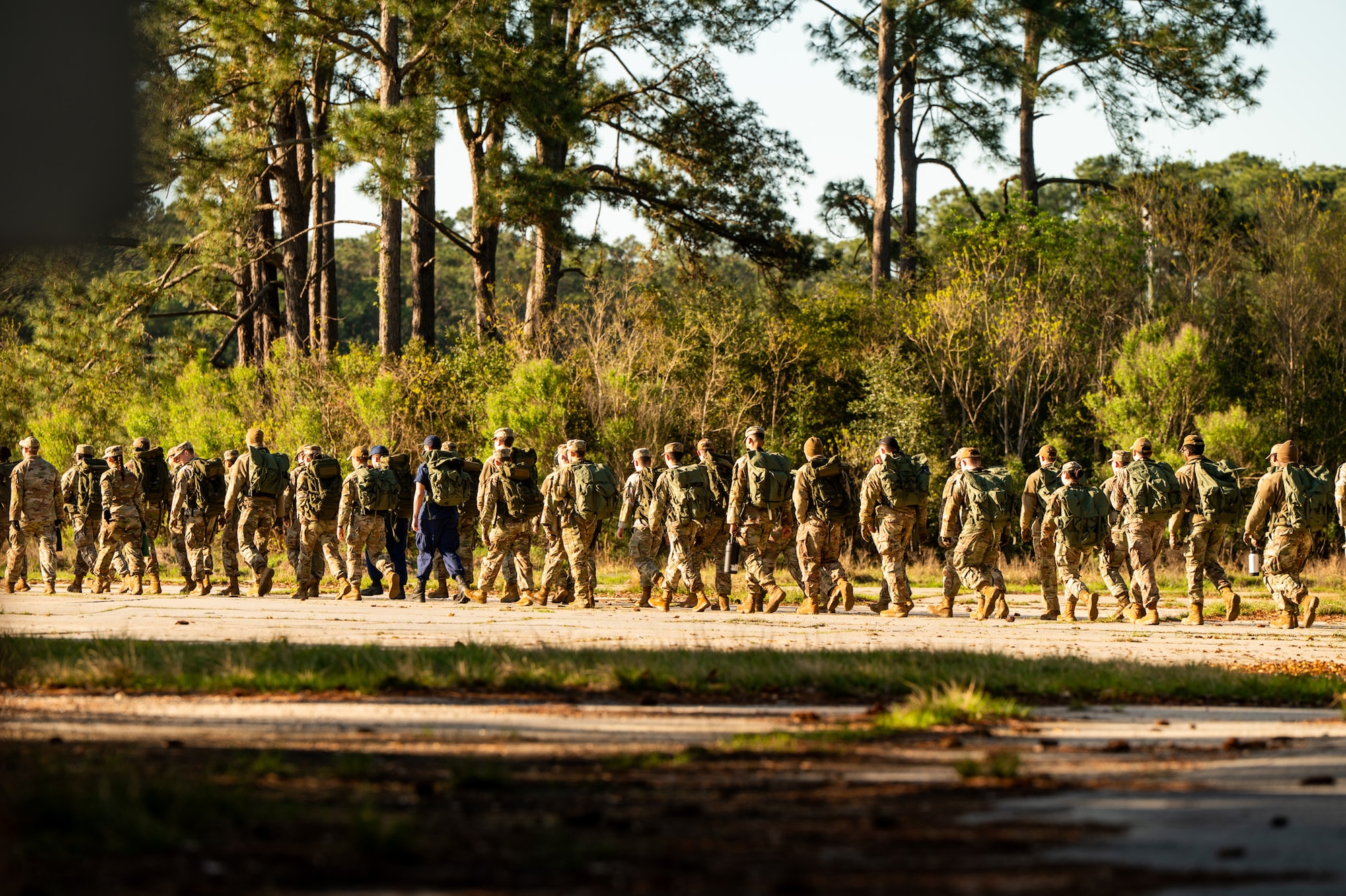 U.S. Marine Corps instructors lead U.S. Airmen and U.S. Coastguardsmen as they march in formation to the first phase of the obstacle course during an Airman Leadership School field training exercise at the Marine Corps Recruiting Depot, Parris Island, South Carolina.