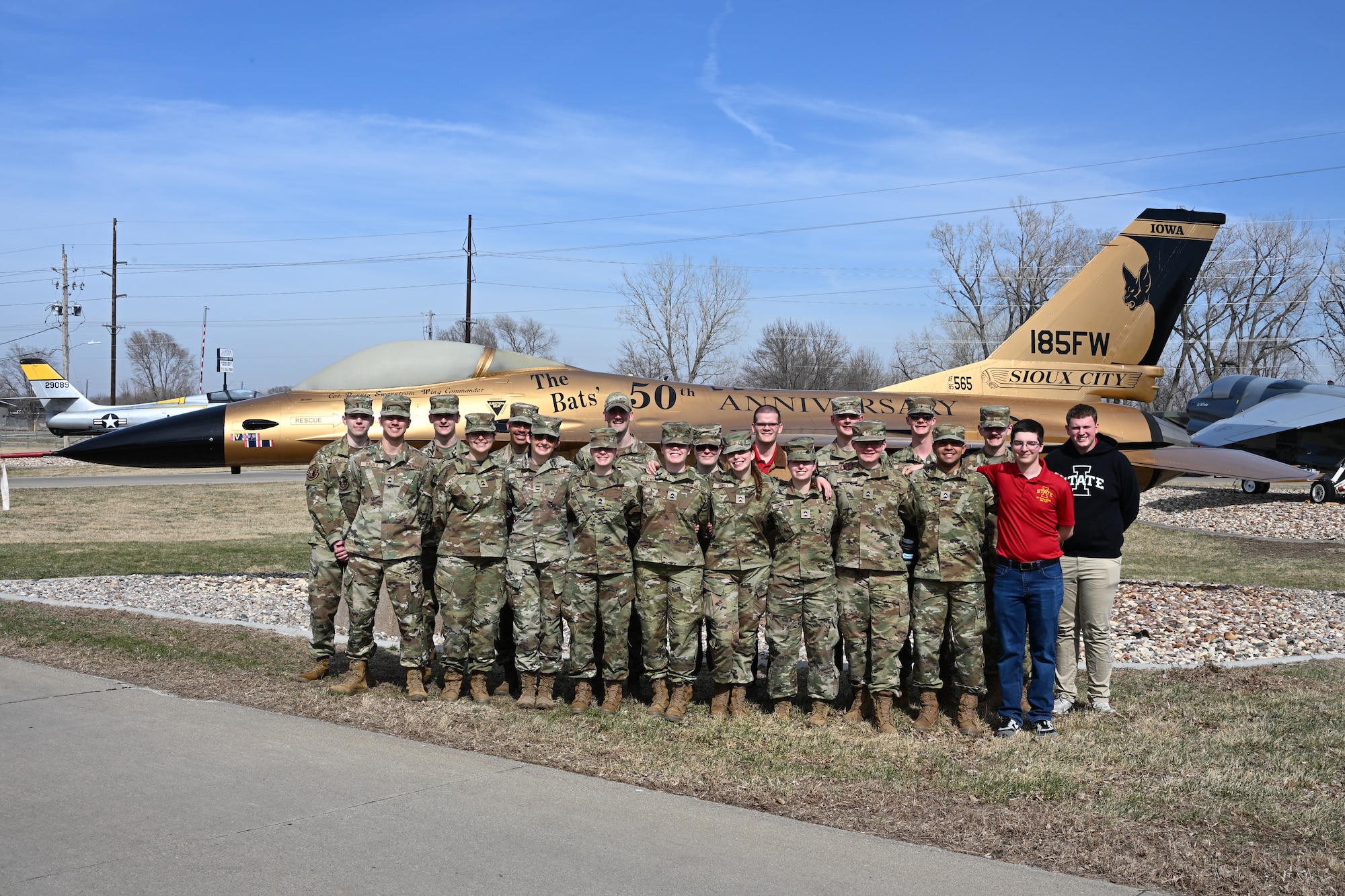 U.S. Air Force Reserve Officers’ Training Corps cadets of Detachment 250 from Iowa State University pose for a photo in front of the gold-painted 50th anniversary F-16 Fighting Falcon static