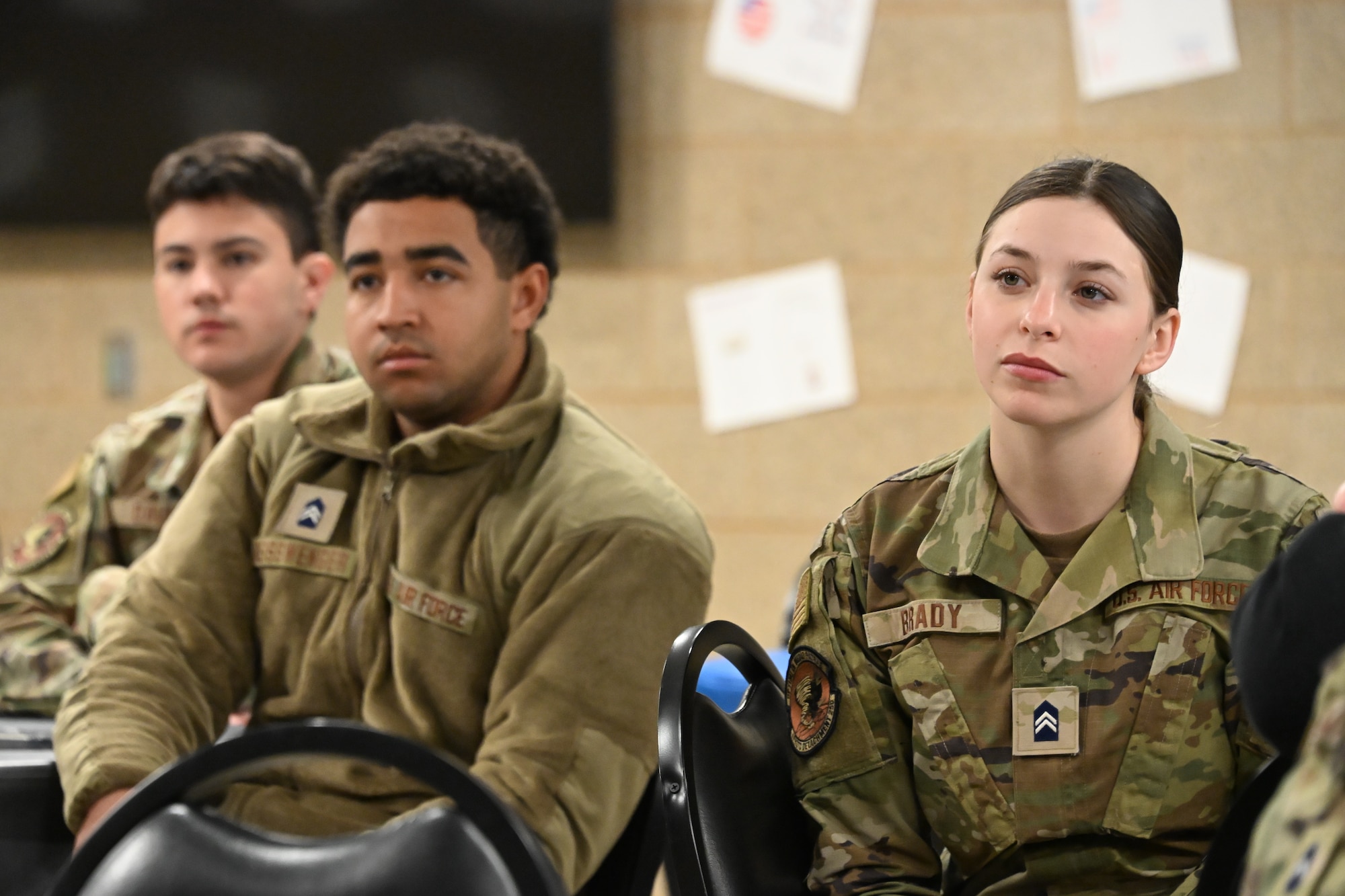 Three Air Force Reserve Officers’ Training Corps cadets are seated in a dining facility.