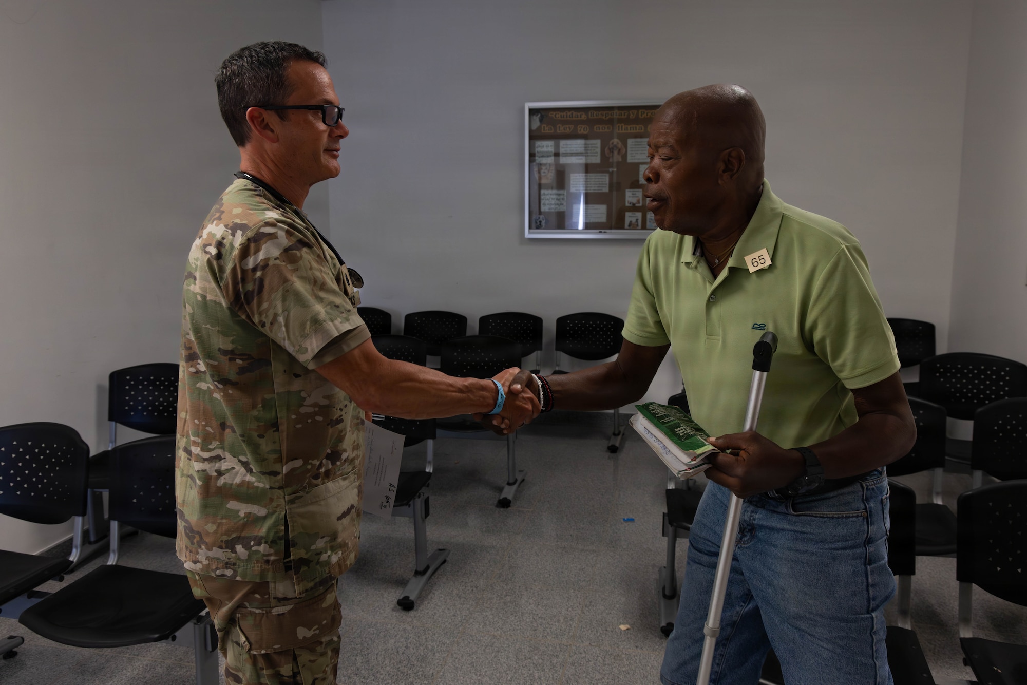 A military member and a patient shake hands