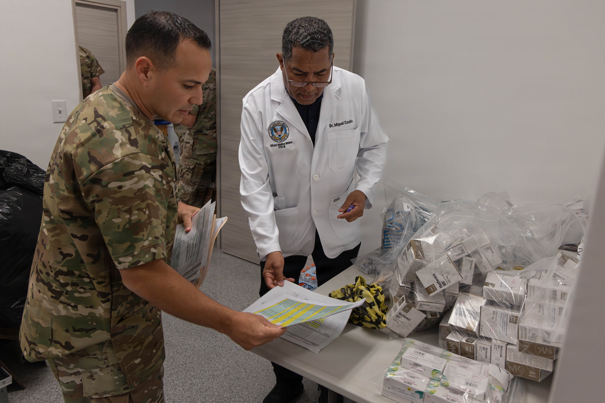 A military member and a doctor look over paperwork