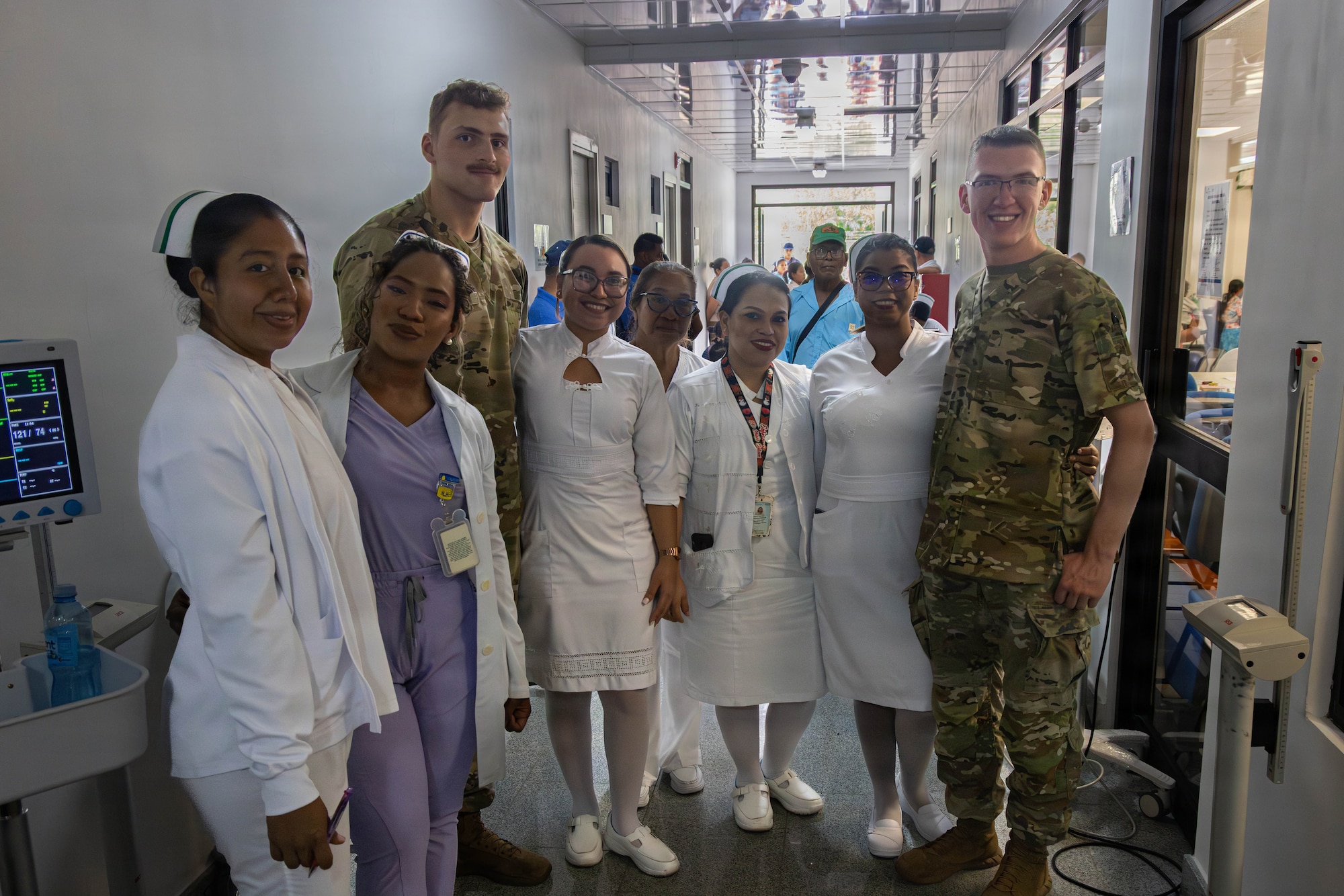 People in military uniforms and medical clothing pose for a photo