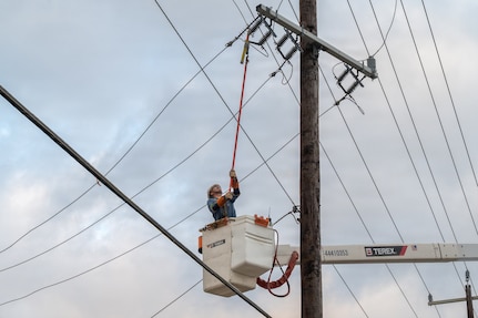 Edgar Esparza, CPS Energy journeyman lineman, disconnects electrical power from a utility pole during an Emergency Resilience Readiness Exercise at Joint Base San Antonio-Lackland, Texas, March 26, 2026. JBSA conducted a preplanned exercise March 24–27 to ensure personnel are prepared to respond to a potential severe weather event and widespread power outage. (U.S. Air Force photo by Marcus Robins)