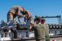 Airmen and Marines prepared live munitions to support 24-hour sortie requirements while strengthening mission-critical skills. With its first class held in 1986, AFCOMAC celebrated its 40th anniversary with the graduation of class 2026-004. (U.S. Air Force photo by Airman 1st Class Ty'Jaih Wallace)