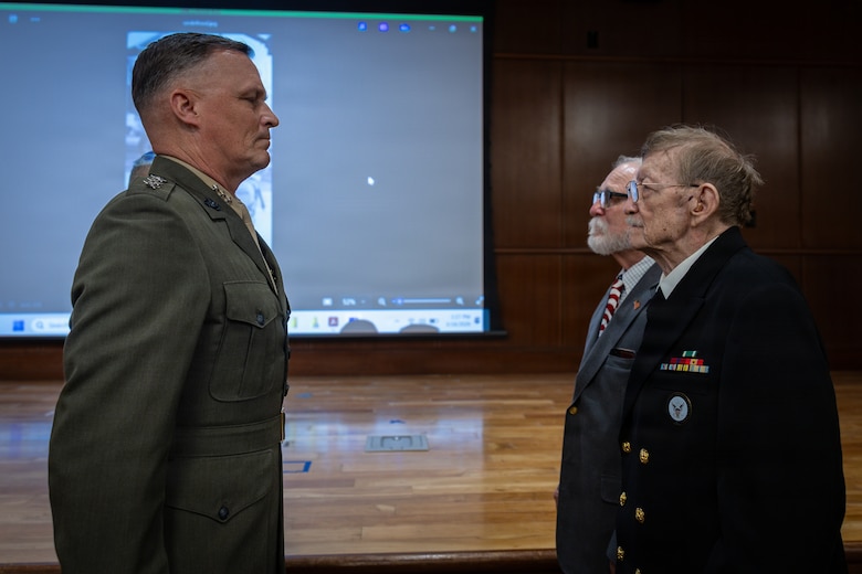 Allan McPherson and Raymond McPherson, right, brothers of the late Maj. Everette McPherson, stand in an award ceremony with Lt. Gen. Leonard F. Anderson IV, left, commander of Marine Forces Reserve and Marine Forces South, during a posthumous Distinguished Flying Cross ceremony honoring the heroic actions of their brother at Marine Support Facility New Orleans, March 18, 2026. The Distinguished Flying Cross is awarded to those who have displayed single acts of heroism or extraordinary achievement while participating in aerial flight. Maj. McPherson, a fighter jet pilot, posthumously received the award for sacrificing his life during the Vietnam War in an attempt to save the life of his co-pilot. (U.S. Marine Corps photo by Lance Cpl. Claire Cheney)