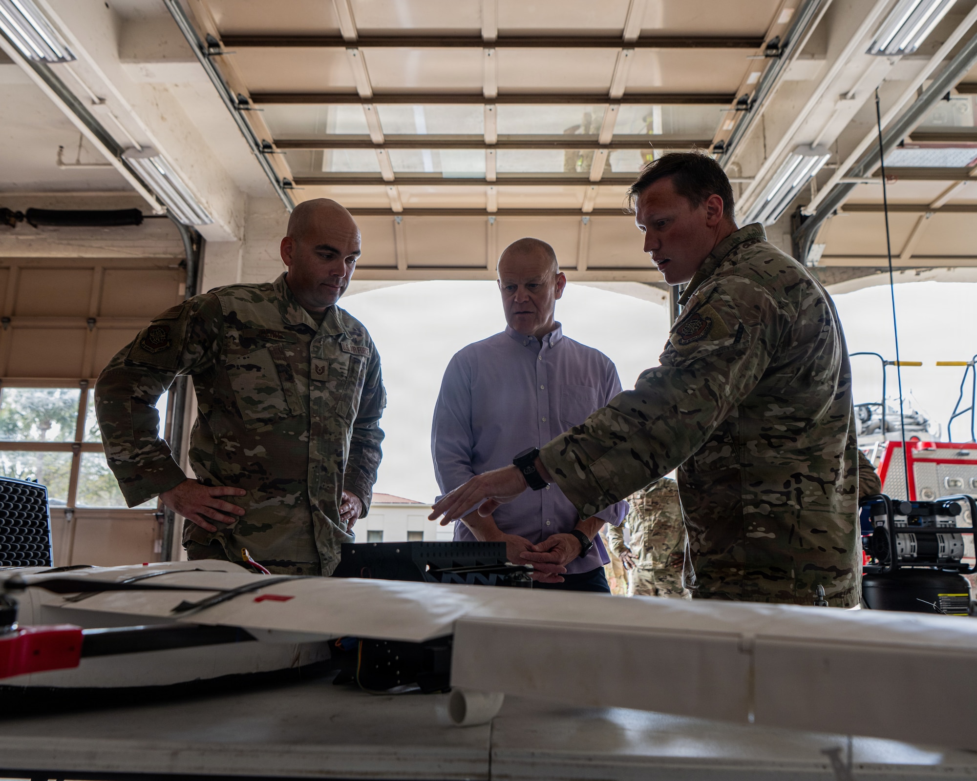 Retired Chief Master Sgt. of the Air Force James A. Roy (middle) is briefed by Tech. Sgt. Matthew Cline (left) and Staff Sgt. Devan Siler, 6th Civil Engineer Squadron explosive ordnance disposal technicians at MacDill Air Force Base, Florida, March 13, 2026. Roy, who began his Air Force career at MacDill in the 56th CES, visited the 6th CES to see the modern mission and priorities upheld by today’s Airmen. (U.S. Air Force photo by Airman 1st Class Helen Ly)