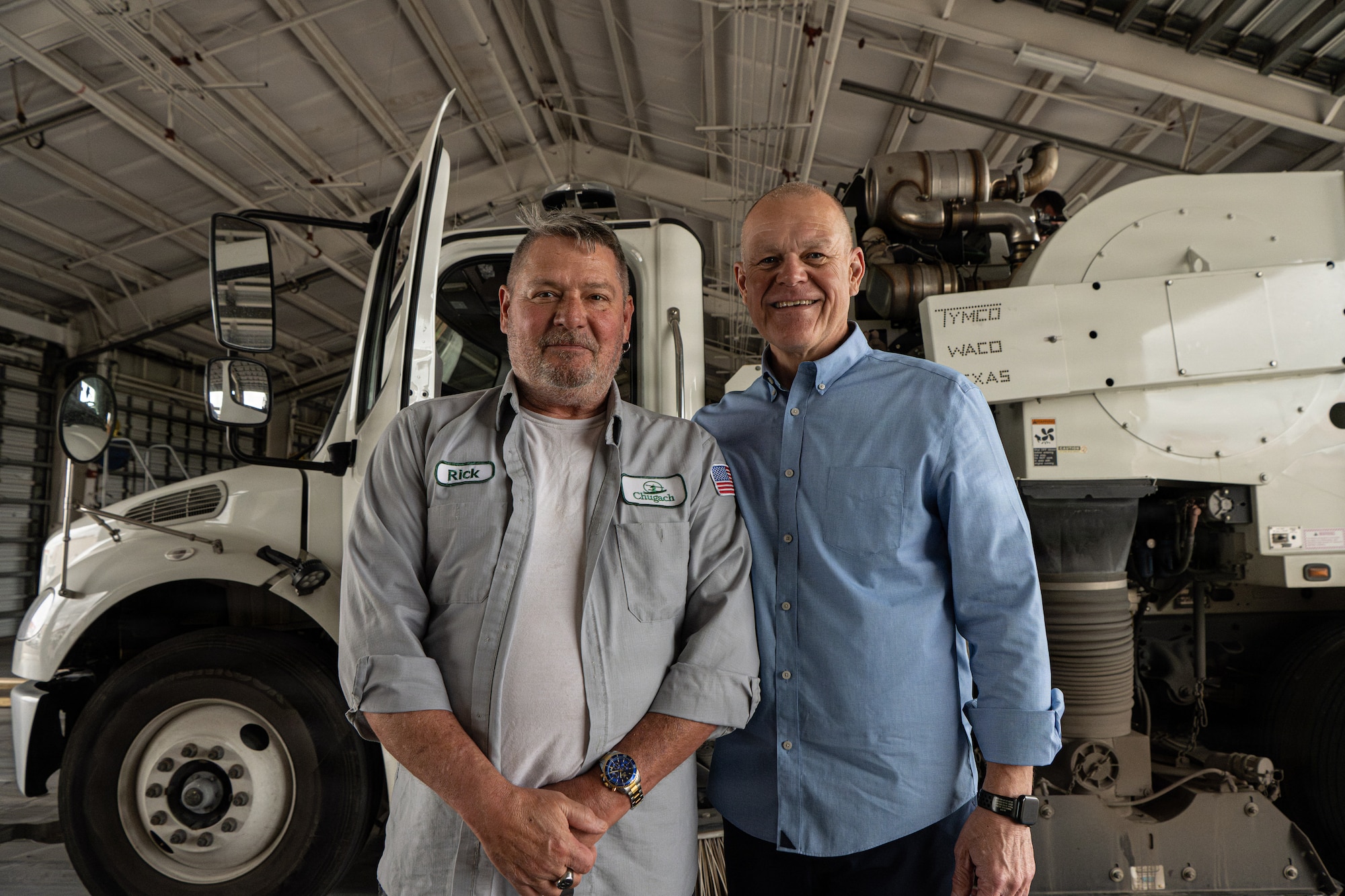Retired Chief Master Sgt. of the Air Force James A. Roy poses with Richard Adams, 6th Civil Engineer Squadron equipment operator/air field sweeper operator at MacDill Air Force Base, Florida, March 13, 2026. Roy began his Air Force career as a pavements and construction equipment Airman, performing the same mission-critical work Adams supports today. (U.S. Air Force photo by Airman 1st Class Helen Ly)