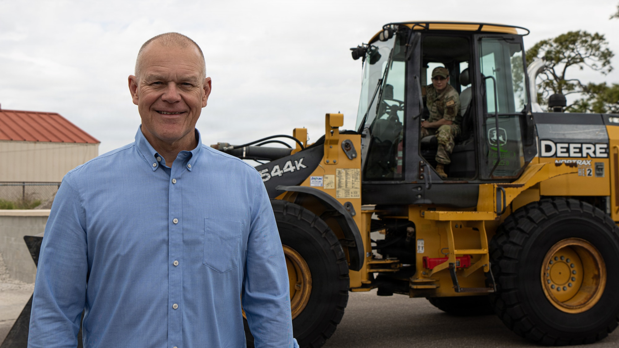Retired Chief Master Sgt. of the Air Force James A. Roy poses in front of a wheel loader operated by Staff Sgt. Thomaz Sturdavant, 6th Civil Engineer Squadron quality assurance evaluator, at MacDill Air Force Base, Florida, March 13, 2026. Roy began his career as a pavements and construction equipment Airman in 1983, a mission-critical role that shaped his path to CMSAF. (U.S. Air Force photo by Airman 1st Class Helen Ly)