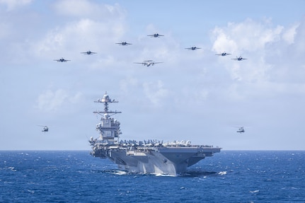 U.S. Navy Carrier Air Wing 8 aircraft fly in formation over the world’s largest aircraft carrier, Ford-class aircraft carrier USS Gerald R. Ford (CVN 78), during Carrier Air Wing 8’s aerial change of command ceremony while underway in the Caribbean Sea, Jan. 19, 2026. U.S. military forces are deployed to the Caribbean in support of the U.S. Southern Command mission, Department of War-directed operations, and the president’s priorities to disrupt illicit drug trafficking and protect the homeland. (U.S. Navy photo)