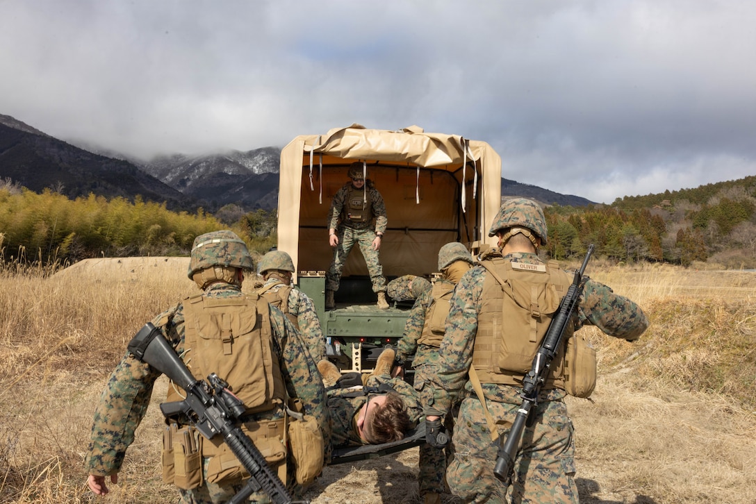 U.S. Marines with Combat Logistics Company 36, Combat Logistics Regiment 35, 3rd Marine Logistics Group, move simulated casualty Cpl. Jack Reinhart, bottom left, a flight equipment technician with Marine Aviation Logistics Squadron (MALS) 12, Marine Aircraft Group 12, 1st Marine Aircraft Wing, and an Iowa native, into a U.S. Marine Corps Joint Light Tactical Vehicle (JLTV) truck assigned to Marine Wing Support Squadron (MWSS) 171, Marine Aircraft Group 12, 1st Marine Aircraft Wing, during mass casualty training as part of exercise Northern Dragon 26 at Japan Ground Self-Defense Force Camp Nihonbara, Okayama, Japan, March 14, 2026. CLC-36 holds exercise Northern Dragon yearly to enhance and maintain the unit’s logistics capabilities, combat marksmanship proficiency, and medical preparedness in austere terrain and weather conditions. (U.S. Marine Corps photo by Cpl. Colin Thibault)