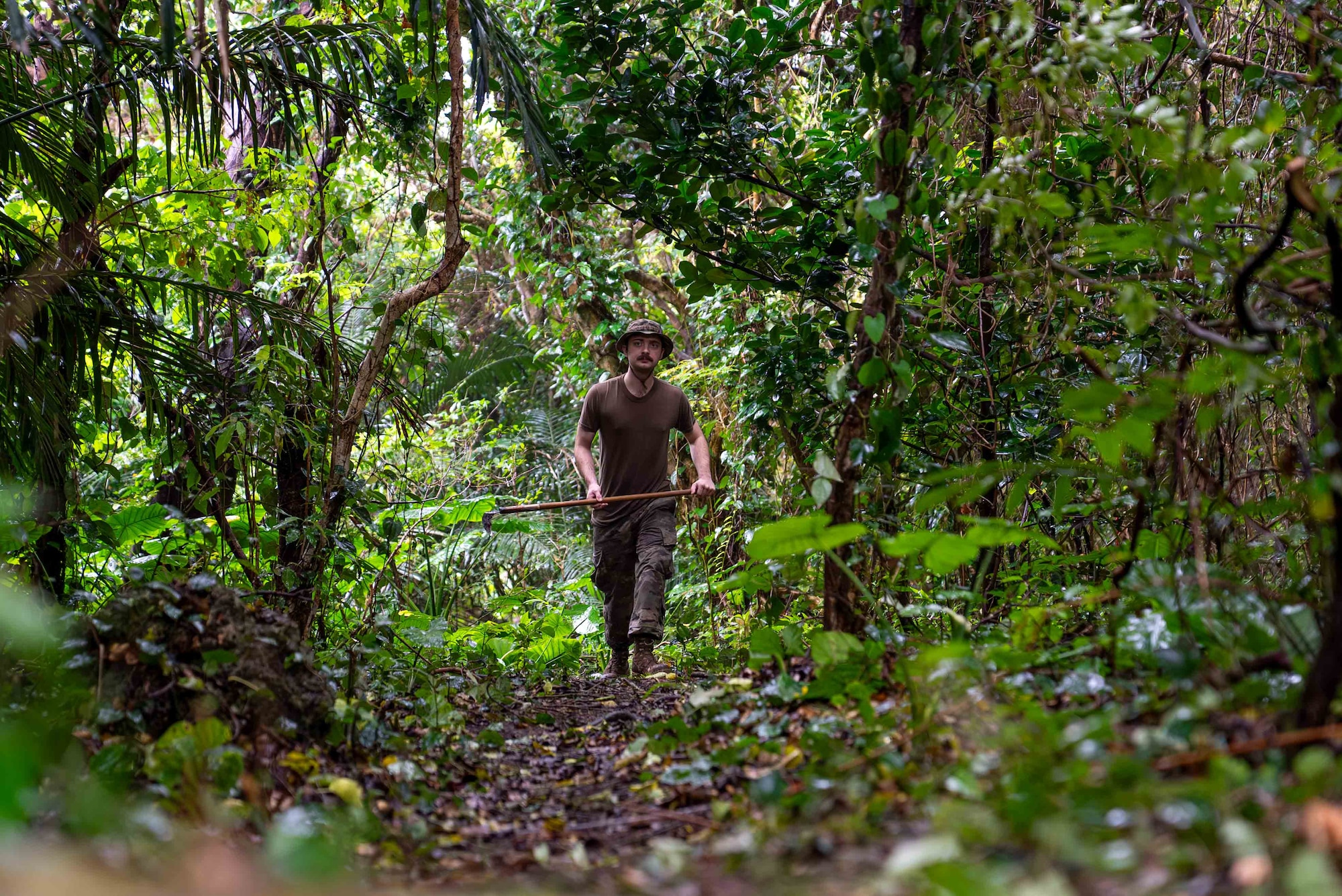 U.S. Air Force Airman Grant Ellis, 18th Munitions Squadron conventional maintenance technician, walks on a path near ancestral tombs after clearing overgrown vegetation in preparation for Shimi at Kadena Air Base, Japan, March 25, 2026.