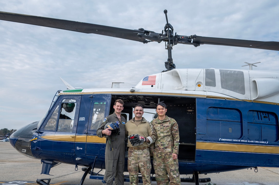 From left, U.S. Air Force Capt. Jack Thackrah, mission pilot, 1st Lt. Jake Streibich, mission pilot, and Airman 1st Class Vietnam Doan, flight engineer, assigned to the 1st Helicopter Squadron take a photo following a flyover for the Baltimore Orioles opening game, at Joint Base Andrews, Maryland, March 26, 2026. The event showcased the planning and teamwork between the 1st HS and game officials to synchronize the flyover with the pregame ceremony. (U.S. Air Force photo by Staff Sgt. Aubree Owens)