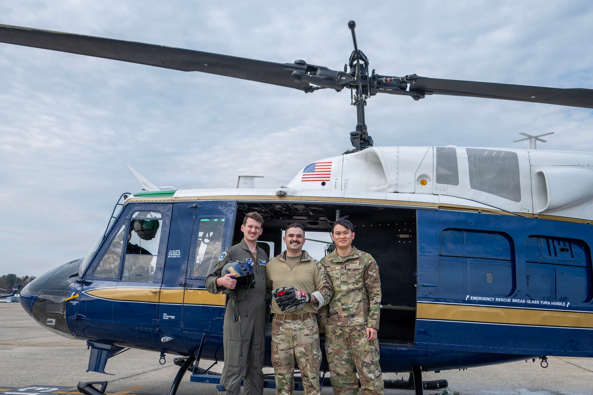 From left, U.S. Air Force Capt. Jack Thackrah, mission pilot, 1st Lt. Jake Streibich, mission pilot, and Airman 1st Class Vietnam Doan, flight engineer, assigned to the 1st Helicopter Squadron take a photo following a flyover for the Baltimore Orioles opening game, at Joint Base Andrews, Maryland, March 26, 2026. The event showcased the planning and teamwork between the 1st HS and game officials to synchronize the flyover with the pregame ceremony. (U.S. Air Force photo by Staff Sgt. Aubree Owens)