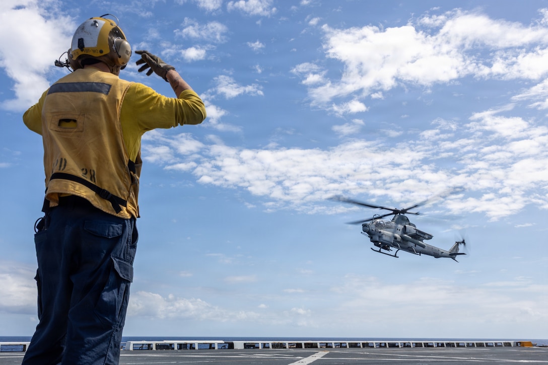 A U.S. Sailor signals to a U.S. Marine Corps AH-1Z Viper helicopter with Marine Medium Tiltrotor Squadron (VMM) 263 (Reinforced), 22nd Marine Expeditionary Unit (Special Operations Capable), as it prepares to land aboard San Antonio-class amphibious transport dock USS Fort Lauderdale (LPD 28), while underway in the Caribbean Sea, March 23, 2026. U.S. military forces are deployed to the Caribbean in support of the U.S. Southern Command mission, Department of War-directed operations, and the president’s priorities to disrupt illicit drug trafficking and protect the homeland. (U.S. Marine Corps photo)