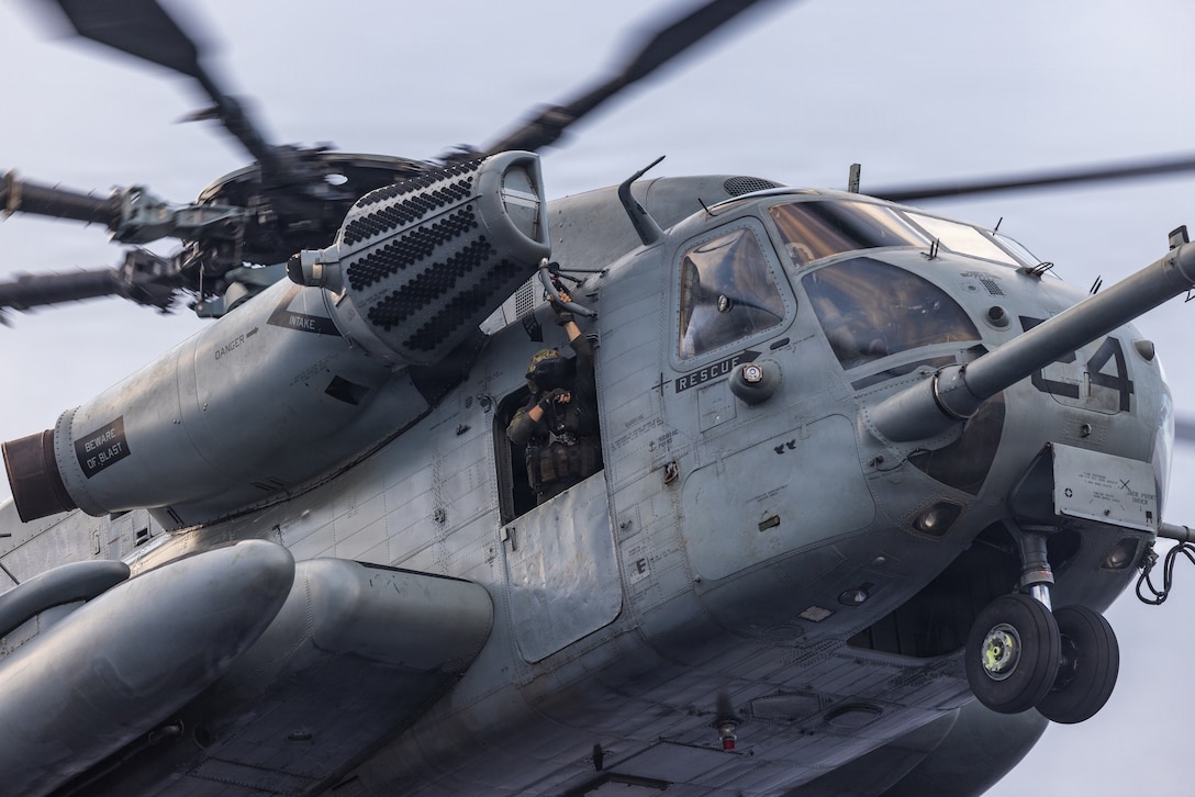 A U.S. Marine with Marine Medium Tiltrotor Squadron (VMM) 263 (Reinforced), 22nd Marine Expeditionary Unit (Special Operations Capable), monitors landing procedures for a CH-53E Super Stallion helicopter during flight operations, aboard San Antonio-class amphibious transport dock USS San Antonio (LPD 17), while underway in the Caribbean Sea, March 16, 2025. U.S. military forces are deployed to the Caribbean in support of the U.S. Southern Command mission, Department of War-directed operations, and the president’s priorities to disrupt illicit drug trafficking and protect the homeland. (U.S. Marine Corps photo)