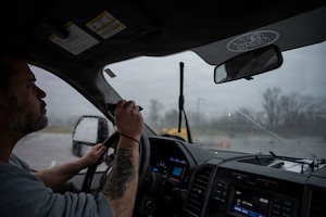 A pest management specialist uses a handheld laser to disperse geese from an airfield at Wright-Patterson Air Force Base to reduce wildlife hazards near aircraft.
