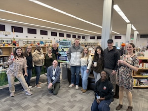 A photo of a woman standing and holding a plaque.
