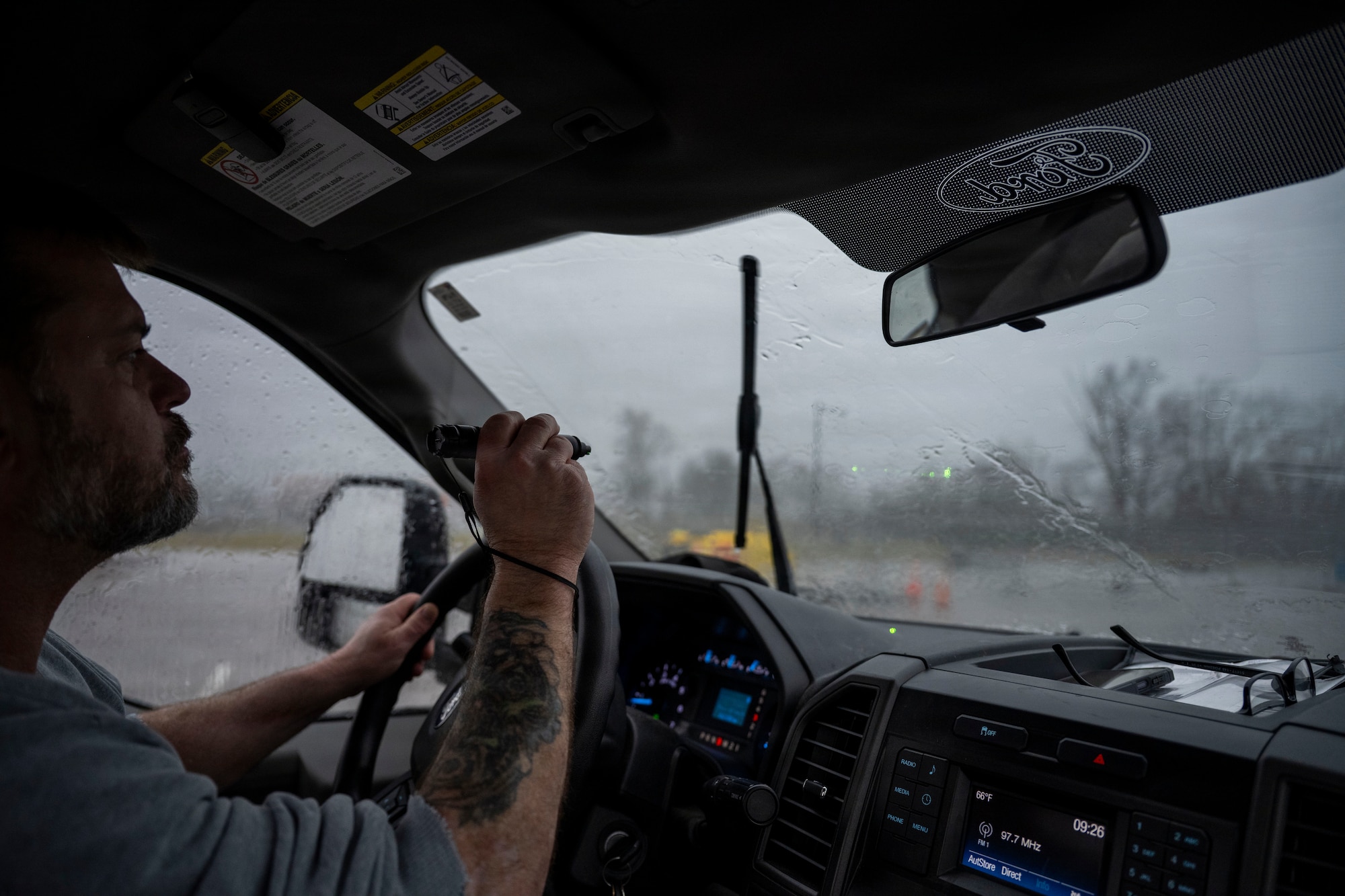 A pest management specialist uses a handheld laser to disperse geese from an airfield at Wright-Patterson Air Force Base to reduce wildlife hazards near aircraft.