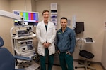 U.S. Army Maj. (Dr.) Charles Miller, and Army Lt. Col. (Dr.) Anthony Tolisano pose in a medical room.