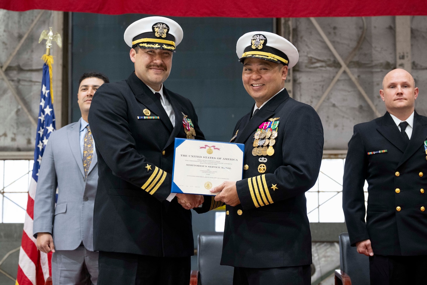 Capt. Randy Cruz (right), U.S. Naval Research Laboratory (NRL) commanding officer, presents a Meritorious Service Medal to Cmdr. Luis Levine, NRL Scientific Development Squadron ONE (VXS) 1 outgoing commanding officer, during the VXS-1 change of command ceremony at Naval Air Station Patuxent River in Patuxent River, Md. March 27, 2026. (U.S. Navy photo by Sarah Peterson)