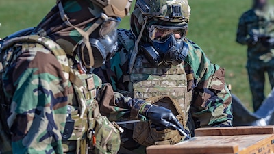 Military Personnel using testing kits in full mopp suits