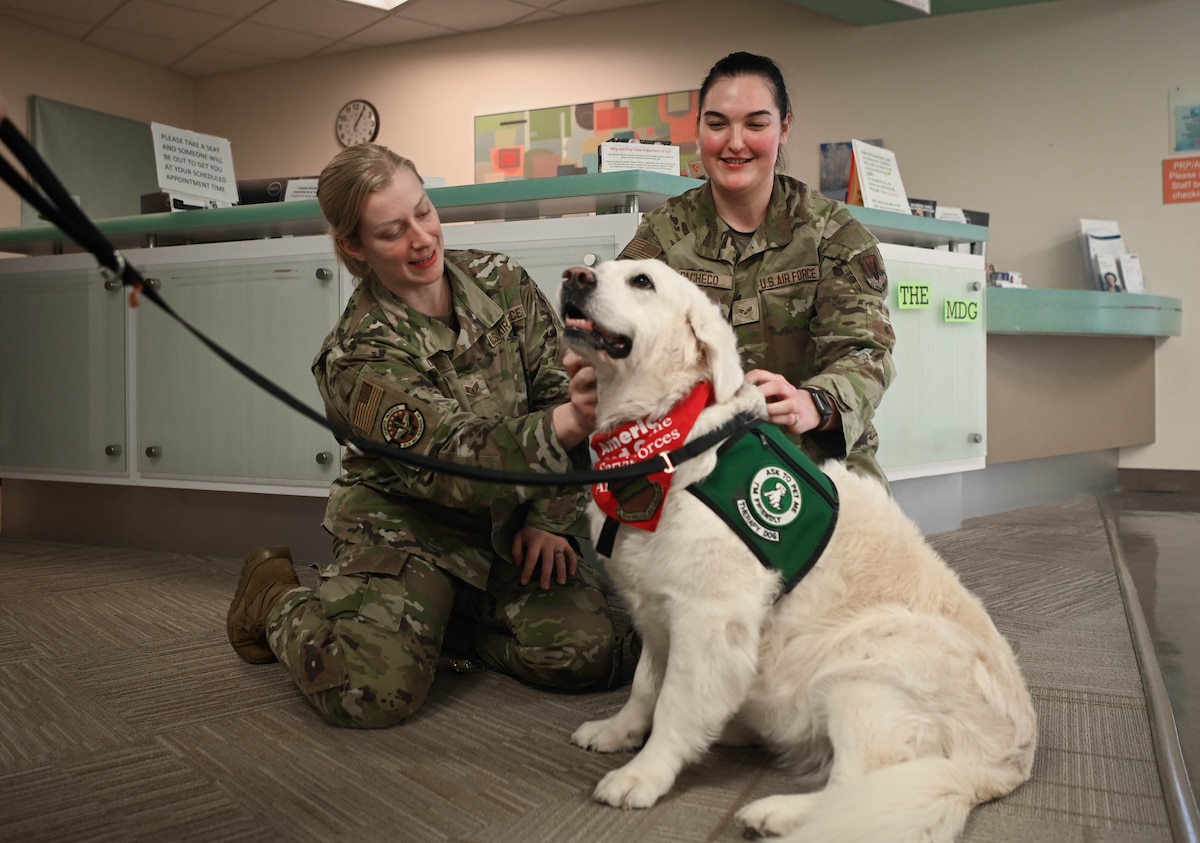 Staff Sgt. Hannah Gerics, 55th Operational Medical Readiness Squadron ophthalmic technician, and Senior Airman Kylie Pacheco, 55th Medical Group medical technician, pet therapy dog, Izy, during her visit to the 55th Medical Group's Ehrling Bergquist clinic in Bellevue, Neb., Jan. 9, 2026. Therapy dogs are tested and evaluated to determine whether they have the personality and demeanor to become therapy dogs. (U.S. Air Force photo by Daniel Martinez)
