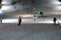 Skiers make their way down a lit slope at Bottineau Winter Park, North Dakota, March. 7, 2026. Bottineau Winter Park is an outdoor recreational park 90 min from Minot Air Force Base. (U.S. Air Force photo by Airman Joseline Chacon Monterroso)
