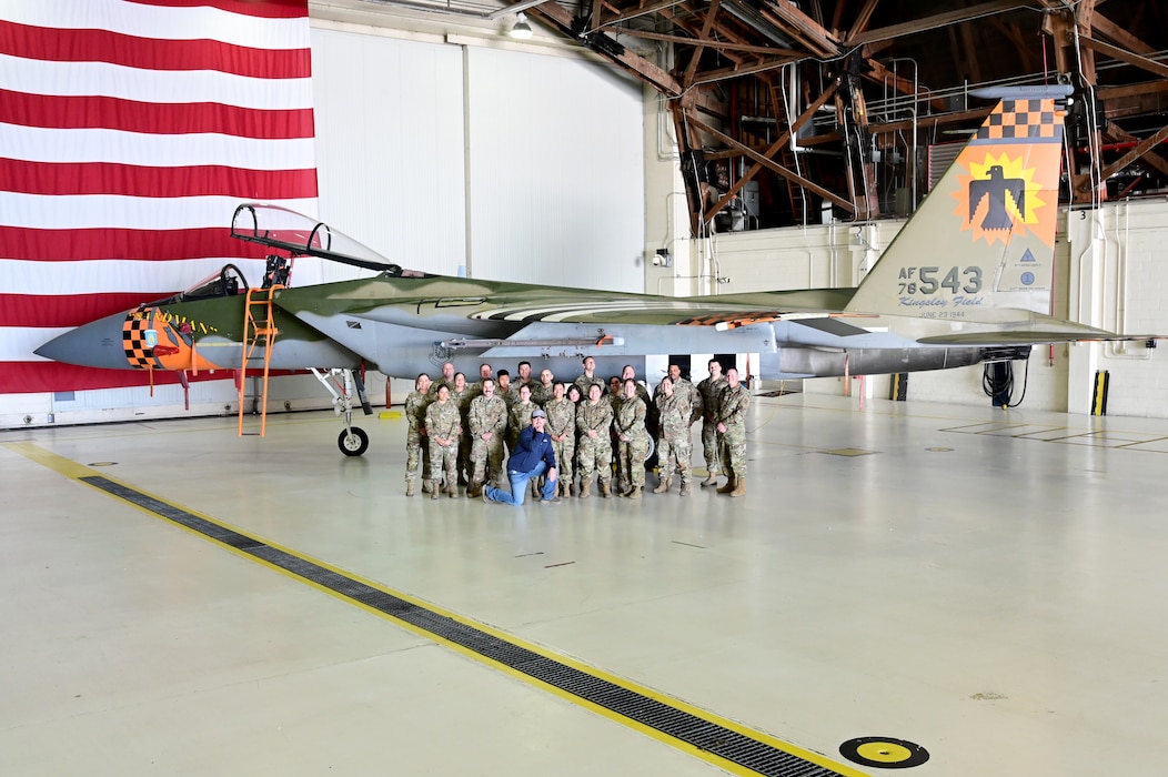 People pose for a picture in front of an F-15