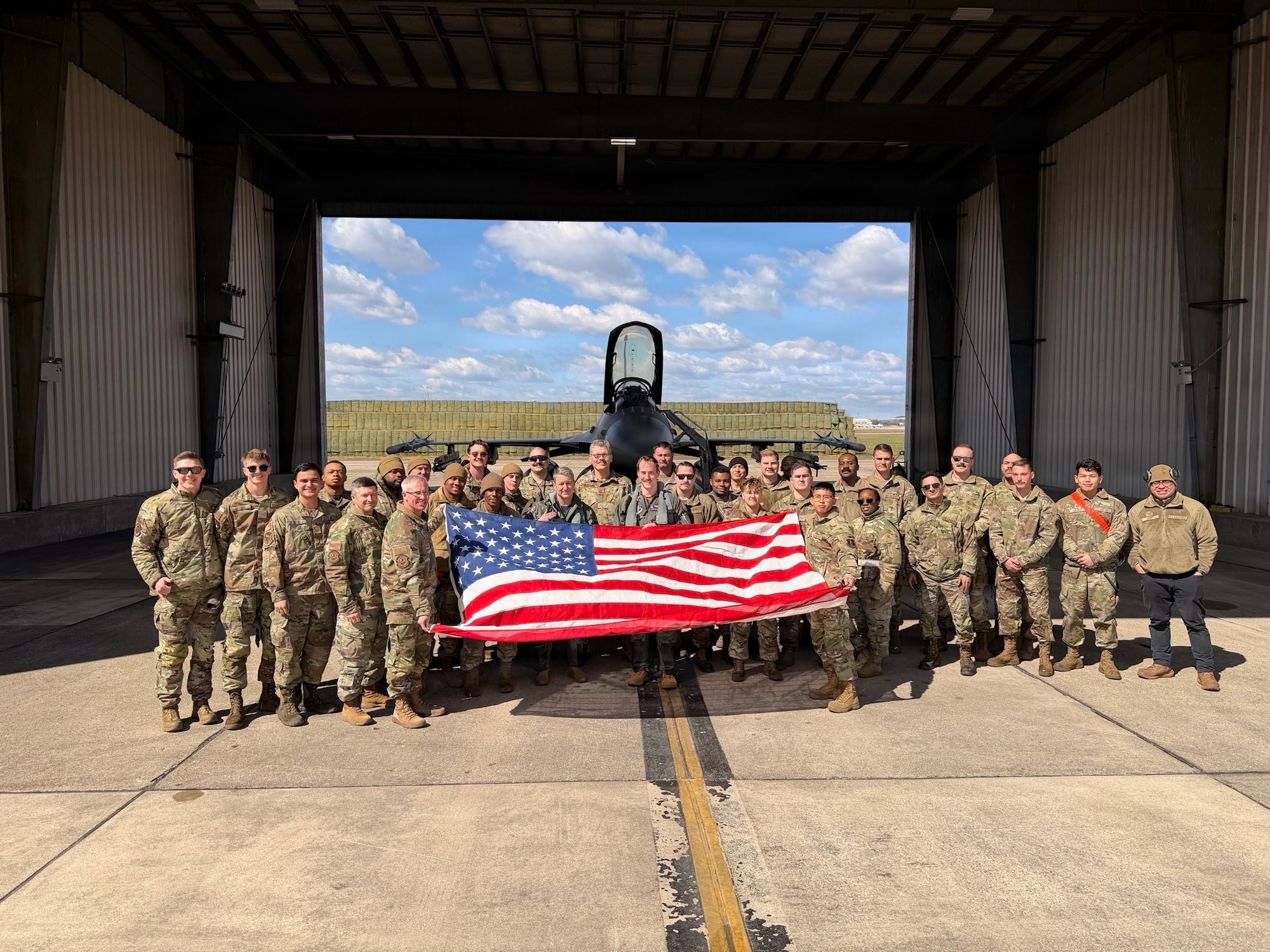 Service members pose with the American Flag