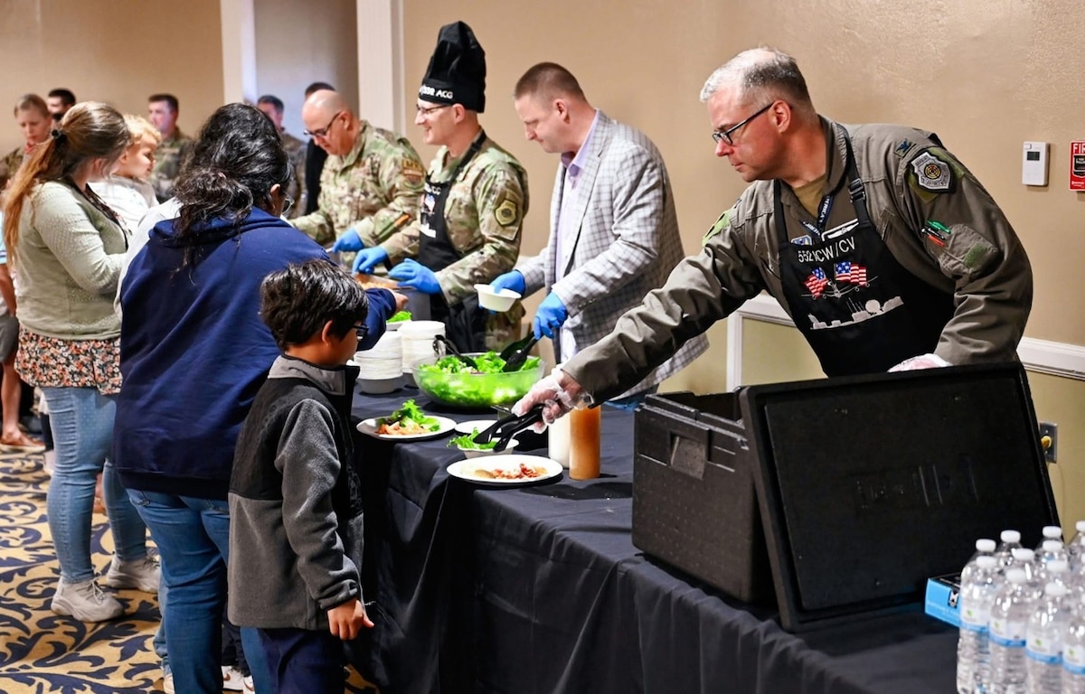 People serving dinner to people in line